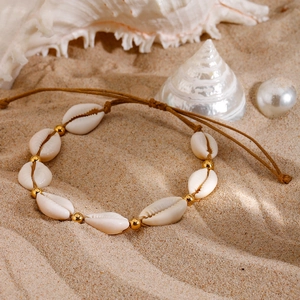 Bohemian adjustable beach anklet with natural white shells and golden metal beads on sand