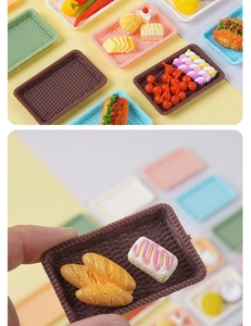Close-up of miniature colorful food trays and pastries with hand for scale