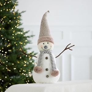 Plush Christmas snowman figurine with grey knit hat and scarf near a festive tree