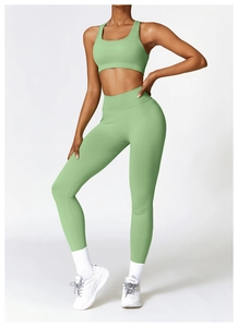Detail of high-waisted seamless light green yoga leggings and matching sports bra set