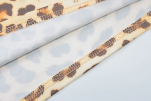 Gros plan du tissu imprimé léopard avec textures beiges et brunes et détails de couture