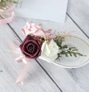 Detail of handmade wedding boutonniere with deep red and pink roses and satin ribbon