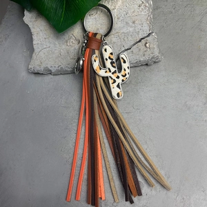 Detail of western-style keychain featuring a leopard print cactus and colorful leather tassels