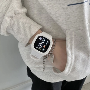 Detail of white digital LED watch worn with silver chain bracelet on a wrist