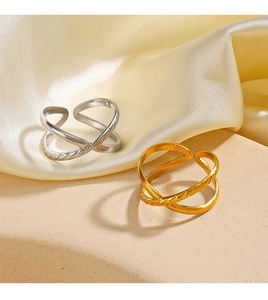 Detail of cross-layered adjustable rings with twisted texture in gold and silver finish