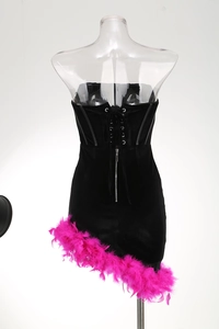Detail of black velvet tube dress with pink feathers, front zipper and lace-up back