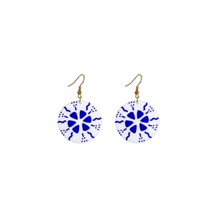 Macro detail of round blue geometric pattern earrings with golden hooks in a vintage style
