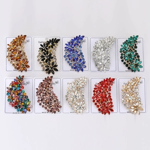 Close-up of ten vintage floral brooches with colorful rhinestones on display cards