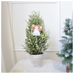 Close-up of a plush angel ornament with metal bell hanging on a mini frosted Christmas tree