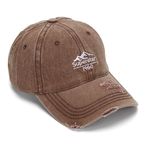 Détail macro d'une casquette en coton délavé marron avec broderie montagne et effet usé