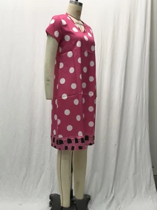 Detail of rose red polka dot dress with V-neck and geometric pattern hemline