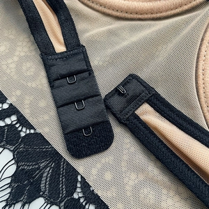 Macro detail of three-row hook-and-eye closure on lace back strap of sexy lingerie bra