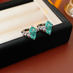 Detail of silver rings featuring pear-shaped turquoise stones and clear diamond accents