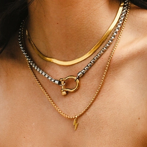 Layered gold snake chain and silver box chain necklace with lightning bolt and clasp pendant
