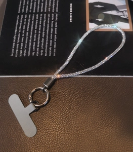 Detail of luxury rhinestone phone lanyard with silver metal ring and gray tether tab
