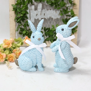 Detail of light blue resin rabbits with woven texture and white bows for Easter decor