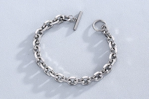 Macro shot of silver stainless steel cable chain bracelet featuring a secure OT toggle clasp
