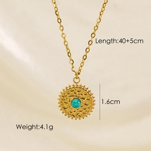 Detail of gold sun pendant with green stone, showing 40+5cm length and 1.6cm size