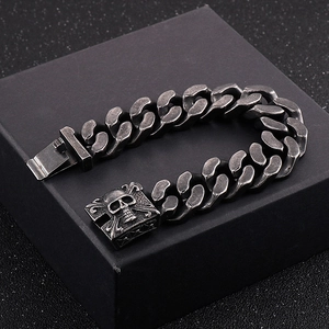 Close-up of vintage silver men's skull link bracelet on a black matte gift box