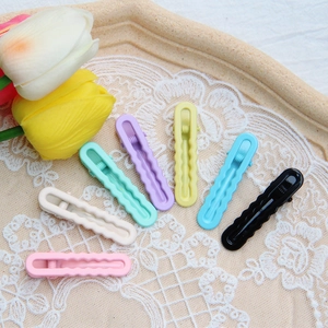 Set of wavy macaron hairpins in seven colors on a lace tray with tulip decor