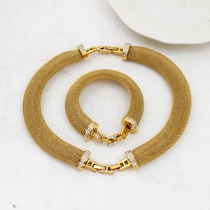 Luxurious 18K gold mesh necklace and bracelet jewelry set with diamond clasps on marble