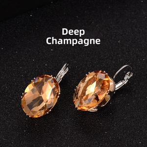 Macro view of lever-back earrings with oval deep champagne crystals on silver base