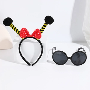 Detail of bee party headband with red polka dot bow and honeycomb patterned glasses