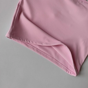 Gros plan de l'ourlet du débardeur de yoga rose avec des détails de double couture