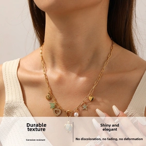 Macro detail of gold-plated ocean theme necklace with colorful sea turtle and shell charms