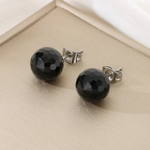 Macro shot of faceted black crystal stud earrings with polished silver steel posts
