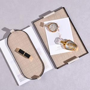 Two woven beige leather storage trays for cosmetics and jewelry with elegant handles