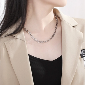 Silver stainless steel pig nose chain necklace shown on a model with a beige blazer