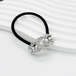 Detailed shot of a black elastic hair tie with silver alloy and white pearl accents