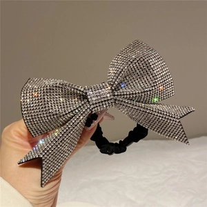 Detailed view of large rhinestone bow hair tie with silver crystals and elastic band