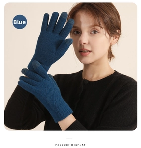 Close-up of blue winter knit gloves featuring touchscreen fingertips and ribbed cuffs