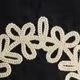 Vue macro de broderies en dentelle crème élégantes sur un tissu noir raffiné