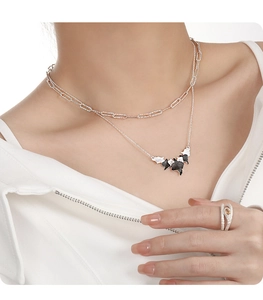 Detail of S925 silver irregular leaf necklace with bicolored pendant and textured ring
