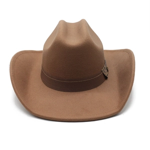Detail of dark brown felt cowboy hat with vintage ribbon and ethnic metal buckle