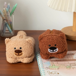Cute teddy bear plush pencil cases in light and dark brown on a wooden desk