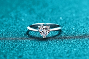 Macro shot of S925 hallmark on heart-shaped silver ring with sparkling teal background