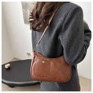 Brown faux leather crescent bag with a decorative pocket and gold hardware detail