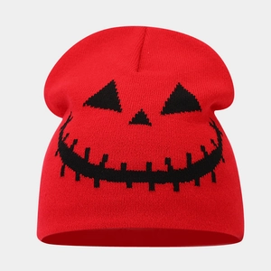 Close-up of red knitted Halloween beanie featuring black jack-o'-lantern pattern detail