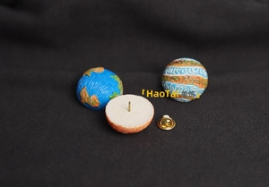 Detail showing the front and back of cartoon planet pins with secure butterfly clutches