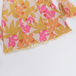 Detail eines geblümten Stoffes mit Volantsaum im rosa-gelben pastoralen Stil