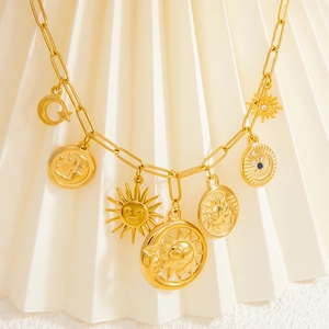 Macro view of gold stainless steel sun and moon charms on a chic chain necklace