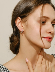 Close-up of S925 sterling silver hoop earrings with inlaid turquoise stones on model