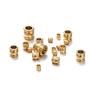 Detailed macro shot of various sized gold stainless steel spacer beads for DIY jewelry