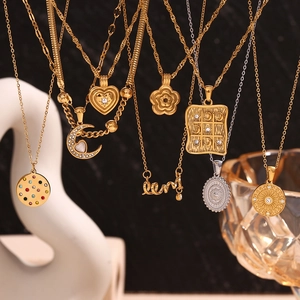 Detailed close-up of 18K gold-plated crescent and heart charms on elegant necklaces
