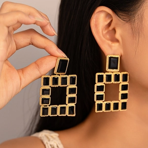 Détail de boucles d'oreilles vintage en or et pierres noires portées par un mannequin