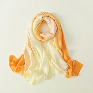 Detailansicht des weichen, seidigen Stoffes mit orange-gelbem Farbverlauf-Effekt